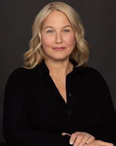 Portrait d’une femme blonde souriante sur fond sombre