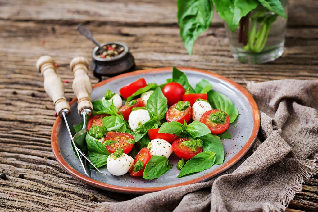 Salade de tomates et basilic préparée avec des ingrédients frais.